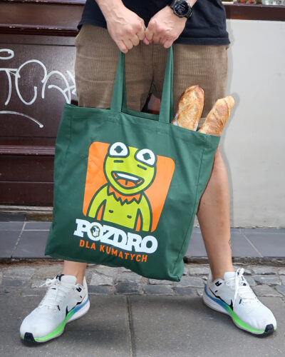 Ciemnozielona bawełniana torba typu tote bag marki Dziedzic Pruski z autorskim hasłem POZDRO DLA KUMATYCH oraz zabawną grafiką przedstawiającą żabę Kermita.